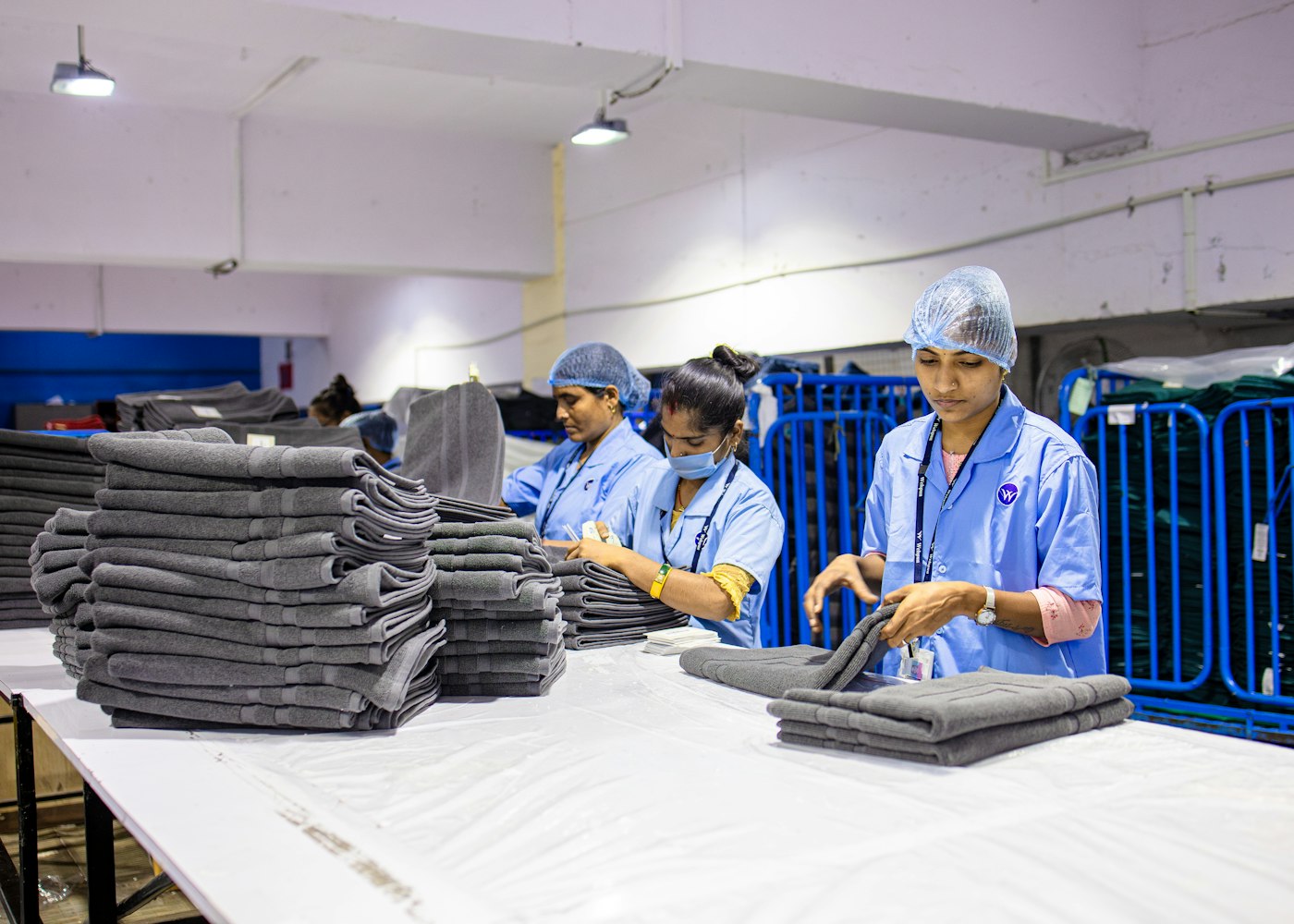 Laundry staff folding and stacking freshly cleaned towels