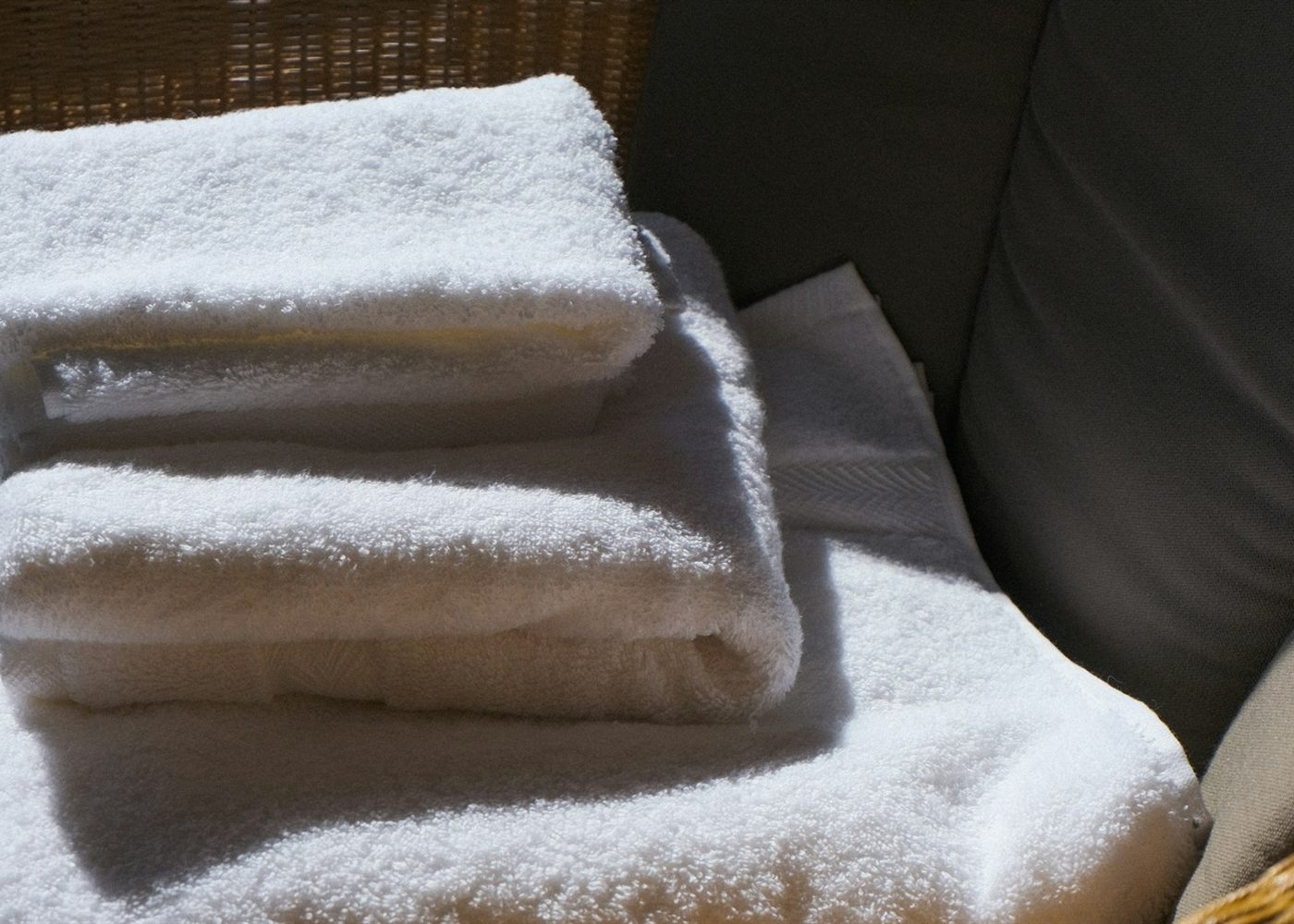 A neat stack of freshly laundered white towels in warm daylight